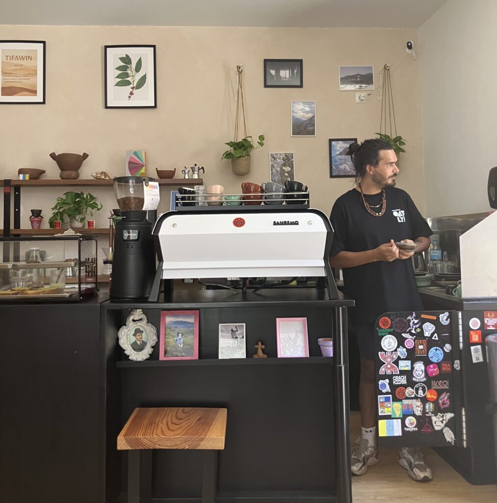 Tifawin Café in San Cristóbal de La Laguna. Man standing behind black coffee bar. 