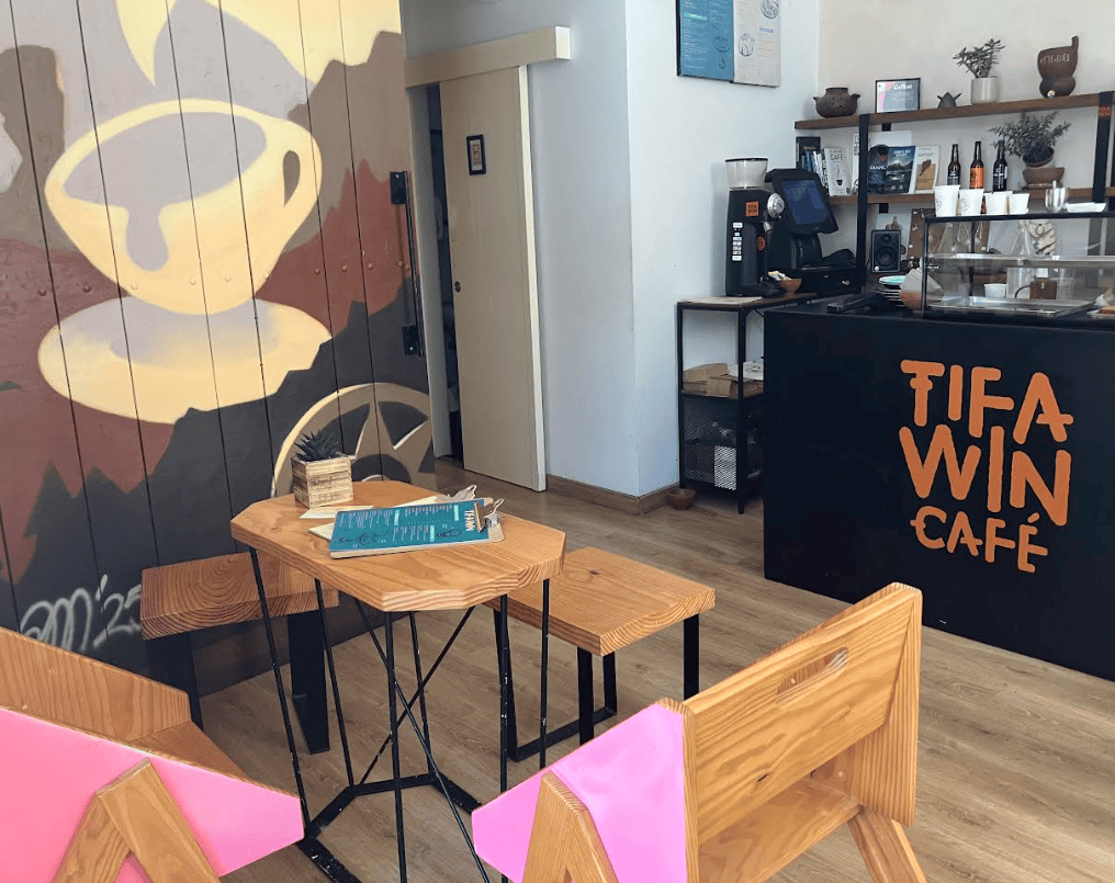 Tifawin Cafe. Coffee cup mural art, wooden chairs and table