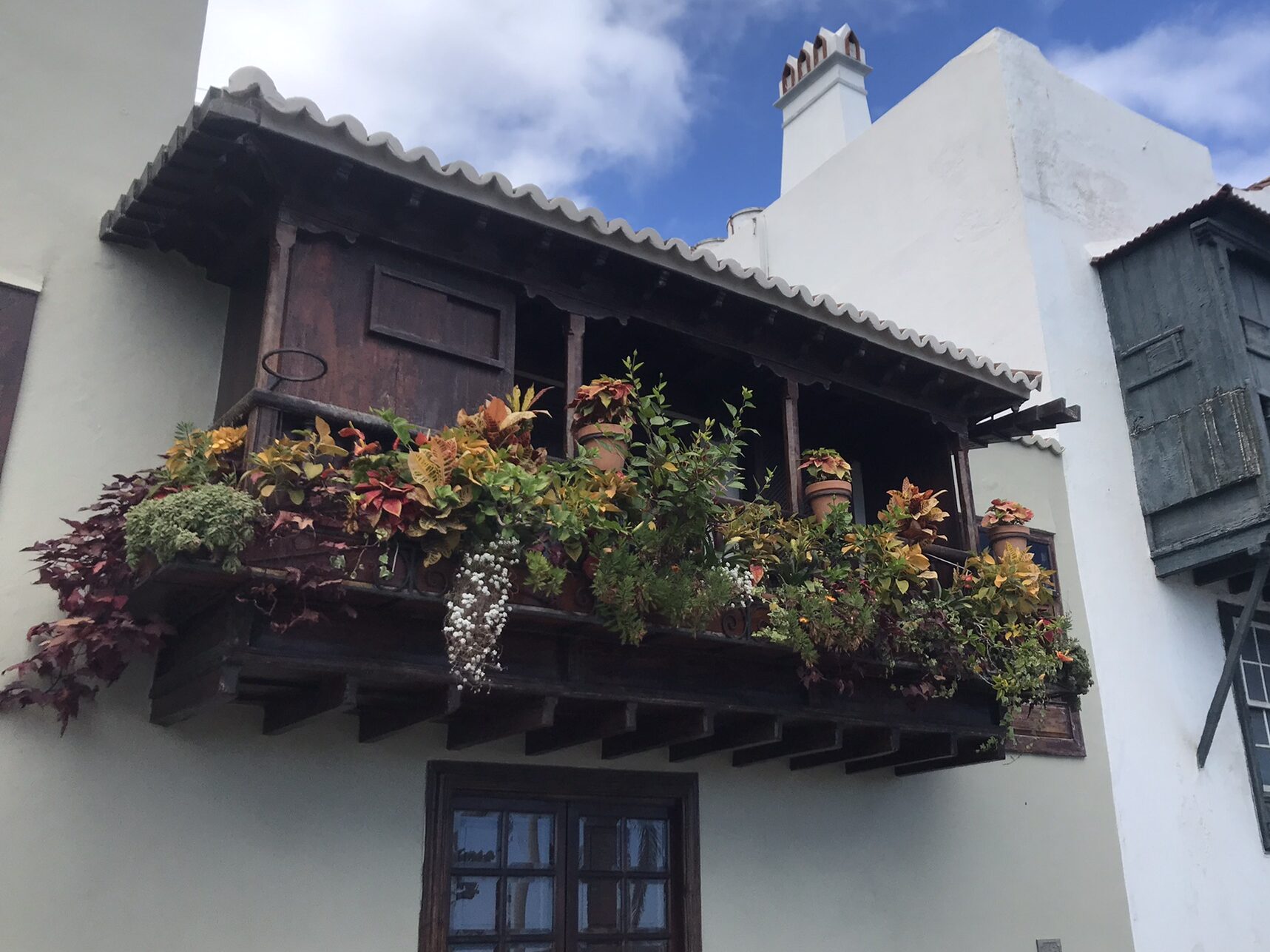 Wooden Balcony ioverflowing with colorful flowers n Santa Cruz de La Palma, La Palma