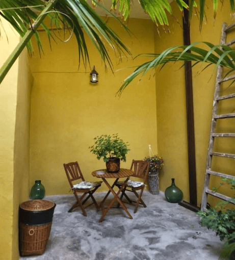 Small table and two chairs in a yellow room.