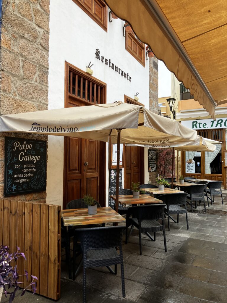 An empty restaurant patio and a sign for octopus. 