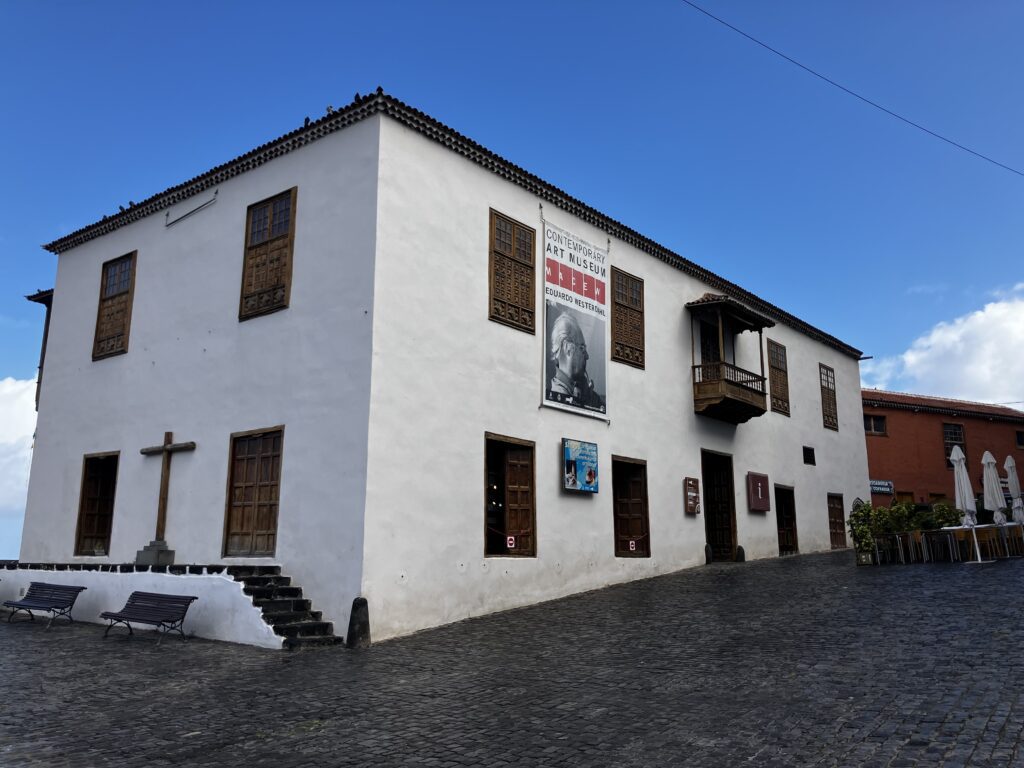 Casa de la Aduana in Puerto de la Cruz, Tenerife. A two story white building with a wooden cross and wooden windows.