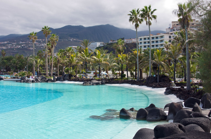 Lago Martianez, one of the best things to do in Puerto de la Cruz, Tenerife. Saltwater pool surrounded by palm trees.