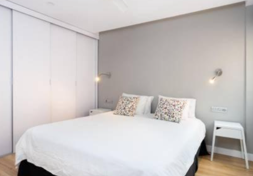 Budget accommodation in El Médano. A simple bedroom with white linens. 